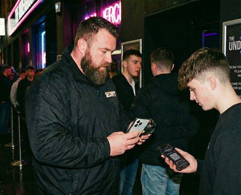 Door staff scanning a ticket on a phone at a venue entrance